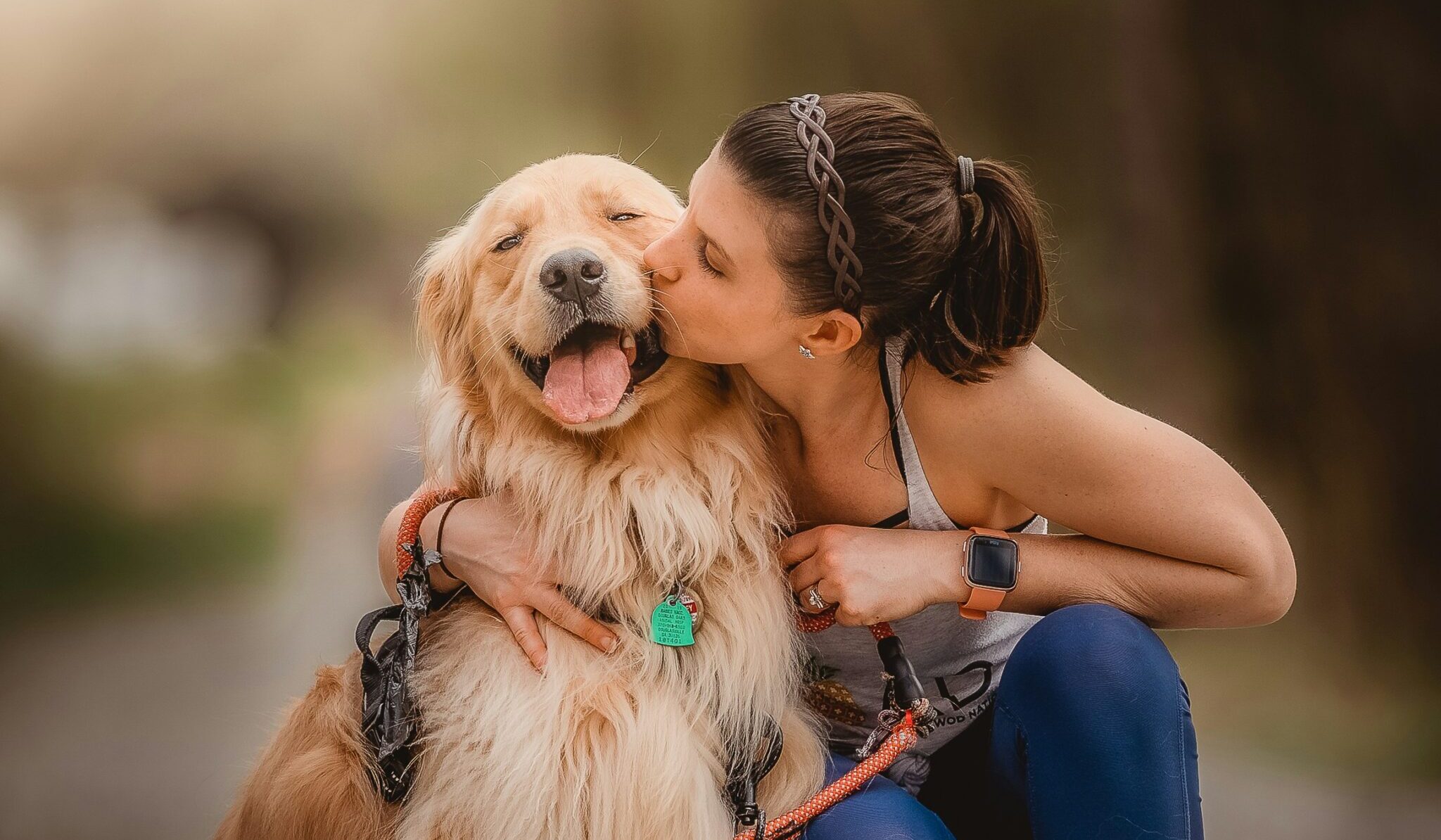 Jeune femme embrassant son golden retriever